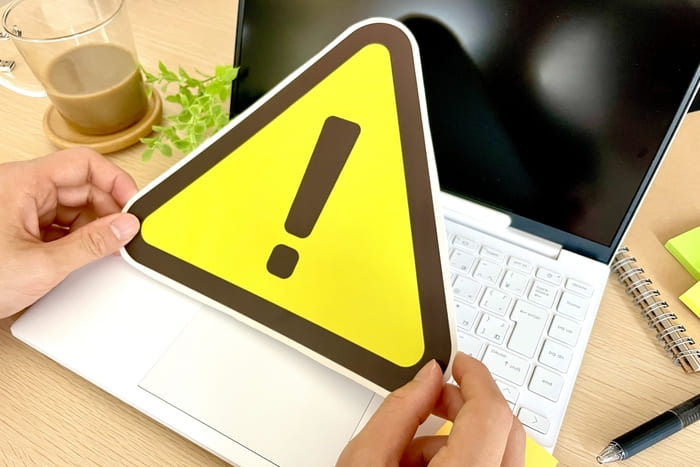 パソコンの上に置かれた黄色い警告マーク