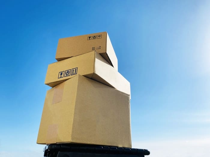 青空の下に積み重ねられた段ボール箱
