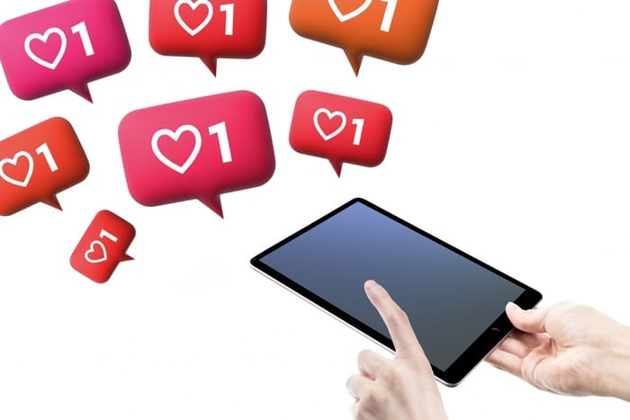 タブレットを操作する手といいね通知